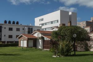 a house in a yard in front of a building at Vista Hotel in Villa Gesell