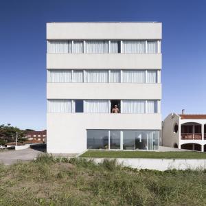 a building with a woman looking out of a window at Vista Hotel in Villa Gesell