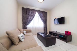 a living room with a couch and a television at Szhnn's Vacation Apartment in Kota Kinabalu