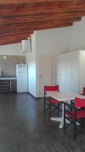 a kitchen with a table and chairs and a refrigerator at Verdeymar in Santa Clara del Mar