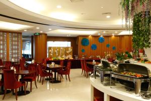 Ramada Nanjing في Jiangning: غرفة طعام مع طاولات وكراسي في مطعم