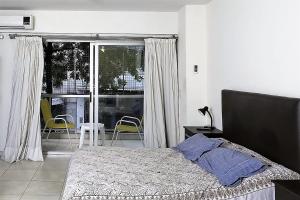 um quarto com uma cama e uma varanda com cadeiras em Darregueyra 2387 em Buenos Aires