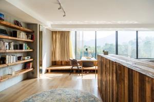 a room with a desk and a table with a window at Anadu Private House in Huzhou