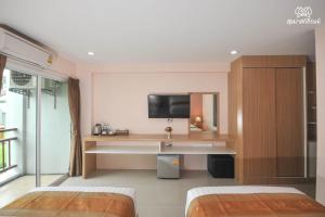 1 dormitorio con 2 camas, lavamanos y TV en Sukkhamas Pirom en Nakhon Ratchasima