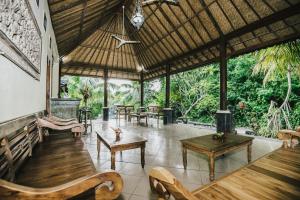 a pavilion with wooden tables and benches and trees at Lembongan Cliff Villas in Nusa Lembongan