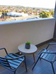 a balcony with two chairs and a table and a window at Liverpool New Apt 2BR and 2Bath in Liverpool