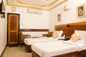ein Hotelzimmer mit 2 Betten in einem Zimmer in der Unterkunft Hotel White House in Kalkutta