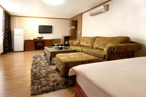 a living room with a couch and a table at Changwon Olympic Hotel in Changwon