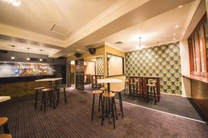 a bar with stools and tables in a restaurant at Heritage Hotel Rockhampton in Rockhampton