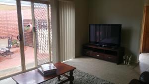 uma sala de estar com uma televisão e uma mesa de centro em Annesley Central em Echuca