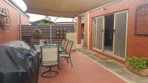 eine Terrasse mit einem Tisch und Stühlen auf einem Backsteingebäude in der Unterkunft Annesley Central in Echuca