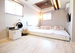 a white couch in a room with two windows at Daemyung Guesthouse in Jeonju