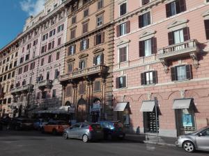 un grand bâtiment avec des voitures garées devant lui dans l'établissement Un Caffè sul Balcone 2, à Rome