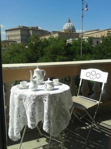 einen Tisch und einen Stuhl mit einem Tee-Set auf dem Balkon in der Unterkunft Un Caffè Sul Balcone 1 in Rom