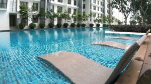 a large blue swimming pool in front of a building at Solstice Service Apartment CYBERJAYA WiFi Netflix KLIA in Cyberjaya
