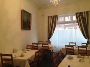 a dining room with tables and chairs and a window at Hotel-Pension Dorma in Berlin