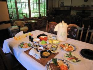 una mesa con platos de comida encima en Onsen Inn 36So, en Matsumoto