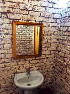 a bathroom with a white sink and a brick wall at Gwango Heritage Resort in Dete