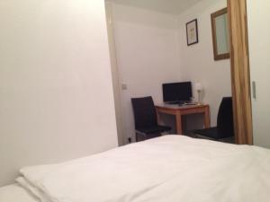 1 dormitorio con 1 cama y escritorio con ordenador en Hotel-Pension Dorma en Berlín