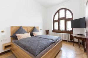 a bedroom with a bed and a desk and a window at Altes Amtsgericht Oppenheim in Oppenheim