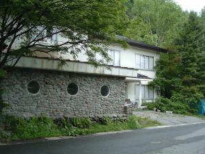 uma casa de pedra com janelas redondas ao lado em Onsen Inn 36So em Matsumoto