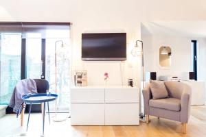 a white living room with a tv and a table and chairs at The Cliffside Chalet - Modern 3BDR Riverside Home in Bath