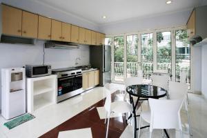 een keuken met witte apparatuur en een tafel en stoelen bij Sun Rise House in Jakarta