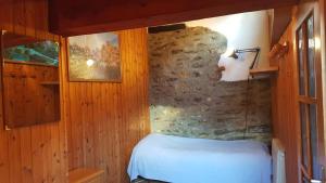 - une chambre avec un lit et un mur en pierre dans l'établissement Euroski B&B, à Aoste