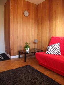 Una sala de estar con un sofá rojo y una mesa. en La villa de chantemerle, en La Bâthie