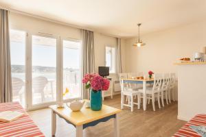 a living room with a vase of flowers on a table at Résidence Pierre & Vacances Cap-Morgat in Crozon