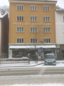 
a white van parked in front of a building at Hotel Les Voyageurs in Modane
