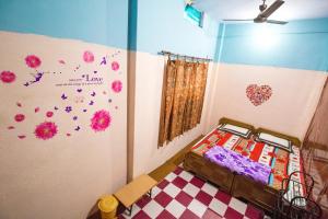 a bedroom with a bed and a wall with flowers at Somit Paying Guest House in Varanasi
