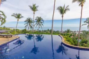 a swimming pool with palm trees in the background at Seaview Paradise Mountain Holiday Villas Resort in Lamai