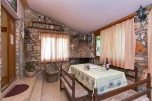a living room with a table and a stone wall at House Fazana 975 in Fažana