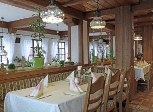 a dining room with a table and chairs and chandeliers at Landgasthof zur Linde in Heimbuchenthal