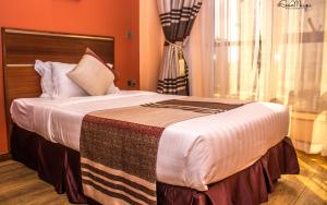 een slaapkamer met een groot bed met oranje muren bij After 40 Hotel in Nairobi