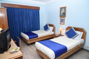 pokój hotelowy z dwoma łóżkami i telewizorem z płaskim ekranem w obiekcie Hotel Clarion w Katmandu