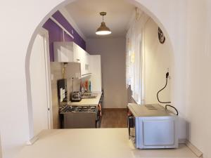 una cocina con un arco en el medio de una habitación en Lia Apartman, en Kiskunhalas