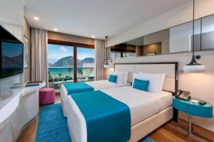 a hotel room with a bed and a view of the ocean at Elite World Marmaris - Adult Only in Marmaris