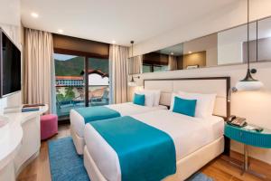 a bedroom with two beds and a balcony at Elite World Marmaris - Adult Only in Marmaris