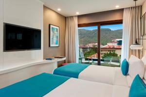 a hotel room with a bed and a large window at Elite World Marmaris - Adult Only in Marmaris