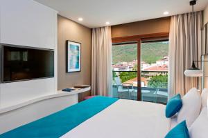 a hotel room with a large bed and a balcony at Elite World Marmaris - Adult Only in Marmaris