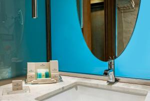 a bathroom sink with a mirror and two boxes of soap at Elite World Marmaris - Adult Only in Marmaris