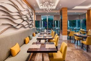 a restaurant with tables and chairs and a chandelier at Elite World Marmaris - Adult Only in Marmaris