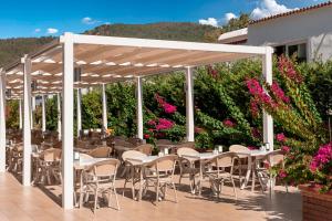 a patio with tables and chairs and flowers at Elite World Marmaris - Adult Only in Marmaris