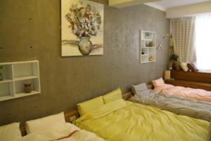 台南市にあるYou Ai Heya Homestayのベッドルーム1室(ベッド2台付)、壁に花瓶1本が備わります。