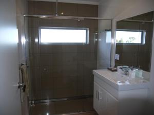 Un baño con ducha, lavabo y espejo. en Spectacular Holiday Living, en Bridport 20 fotos más