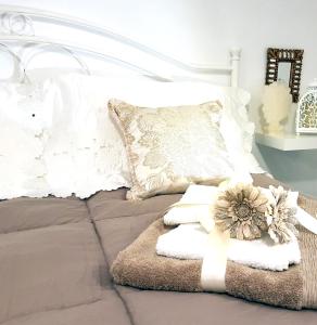 ein Bett mit weißen Kissen und Handtüchern darauf in der Unterkunft Civico 20 Casa d'arte in Monopoli