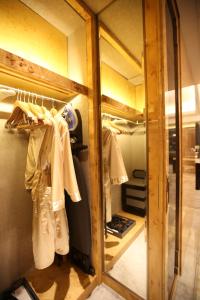a dressing room with a mirror and a closet at Wanda Reign on the Bund in Shanghai