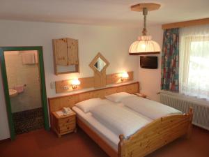 a bedroom with a large bed and a mirror at Pension Appartement Ambrosi in Heiligenblut
